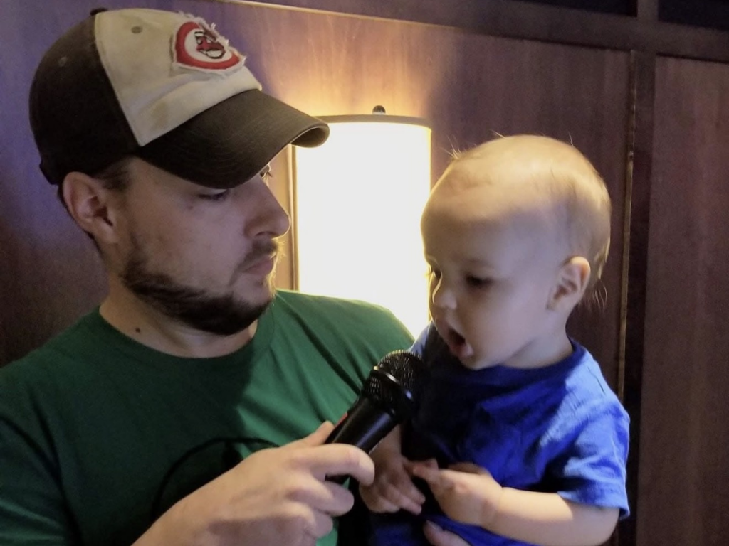 Bob giving the microphone to his son at a C-Town Entertainment trivia night